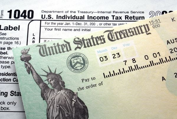 A 1040 tax form is partially covered by a United States Treasury check.