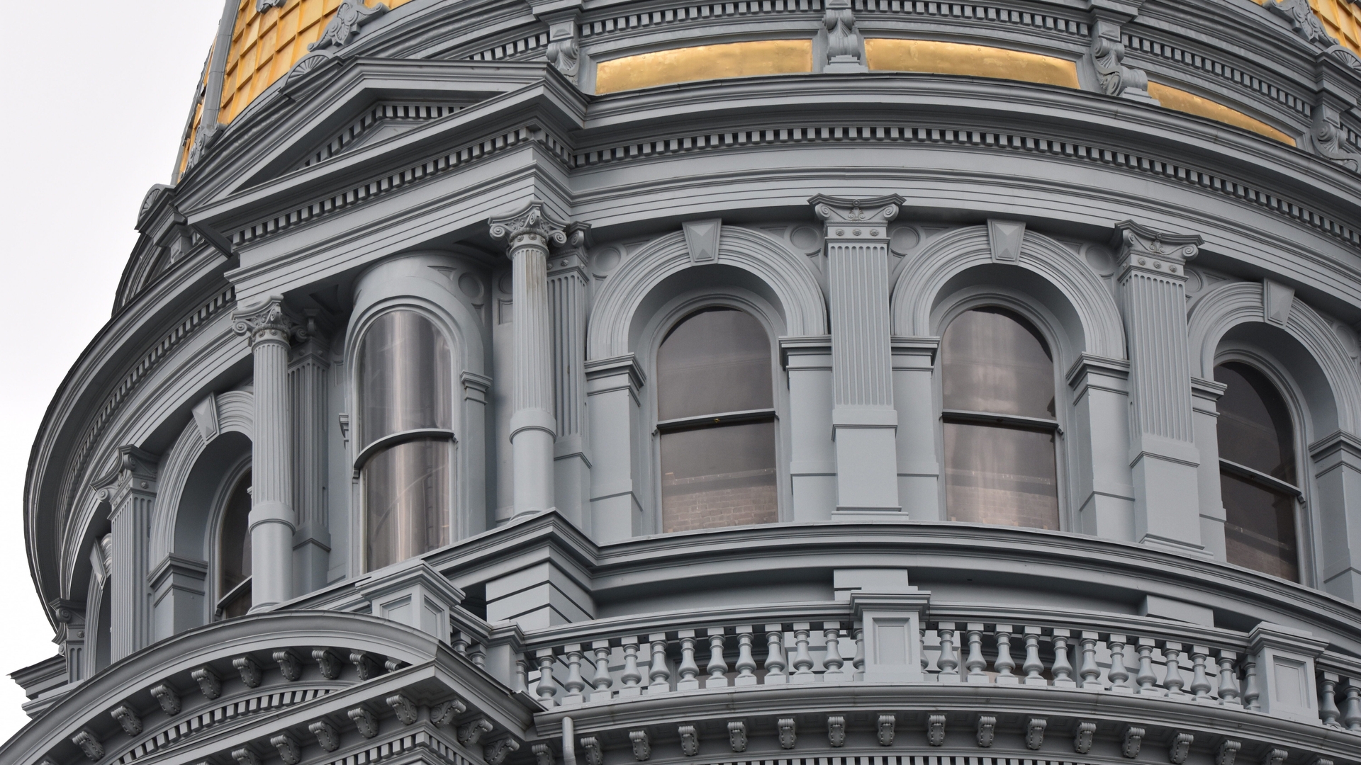Close-up of the exterior windows and gold dome of the Colorado State Capitol Building.